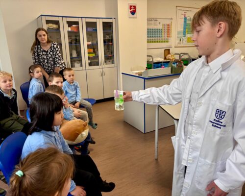 Secondary student presenting experiment in KEIS science room to primary children