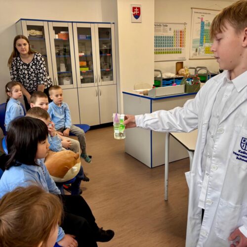 Secondary student presenting experiment in KEIS science room to primary children