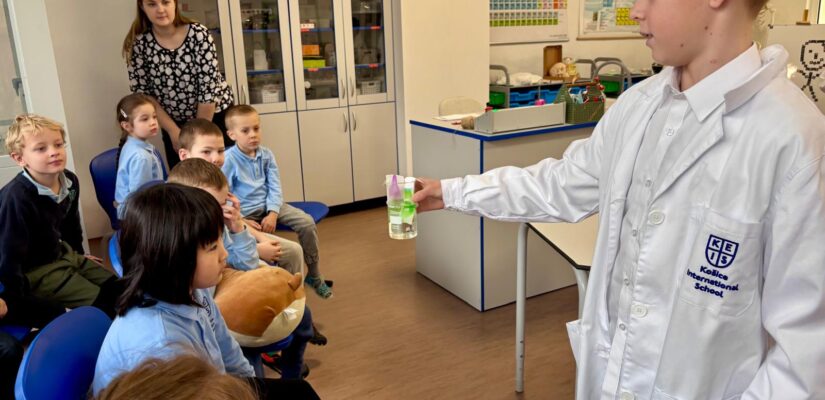 Secondary student presenting experiment in KEIS science room to primary children